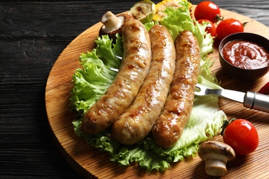 Delicious sausages and vegetables served for barbecue party on wooden table