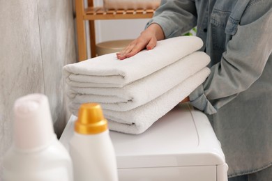 Photo of Woman with stack of clean towels indoors, closeup