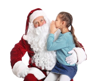 Photo of Little girl whispering her Christmas wish to Santa Claus on white background
