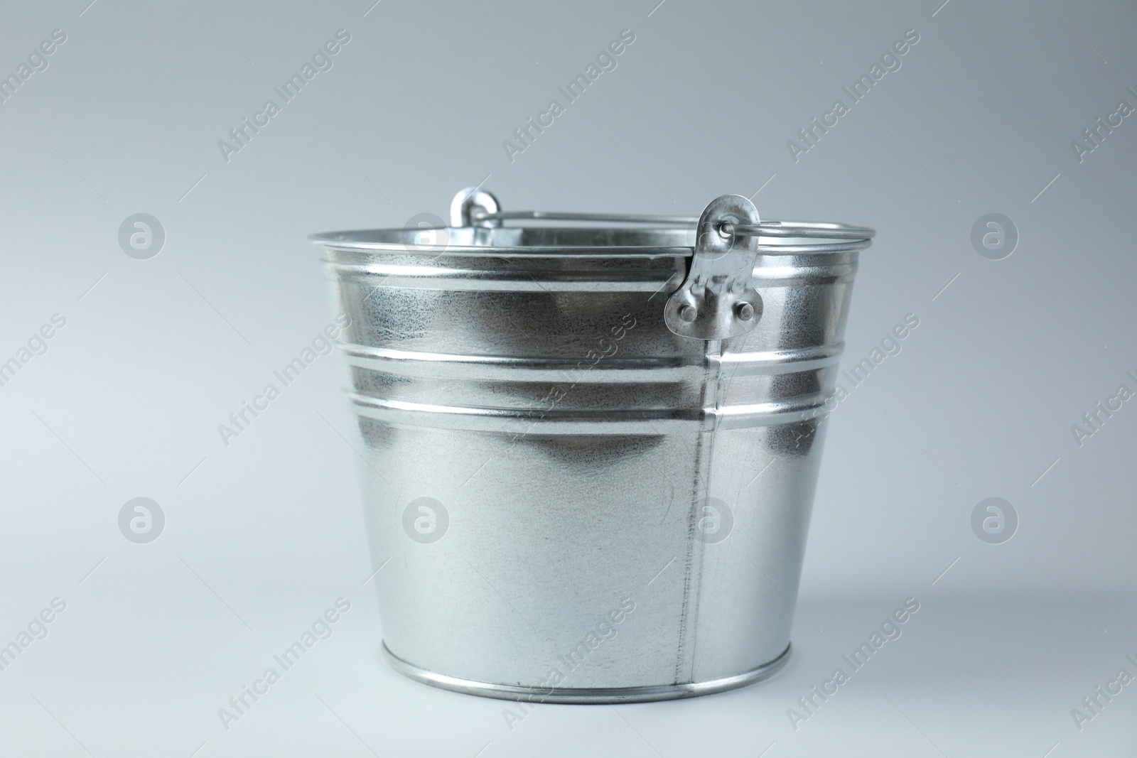 Photo of One shiny metal bucket on white background