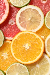 Different sliced citrus fruits as background, top view