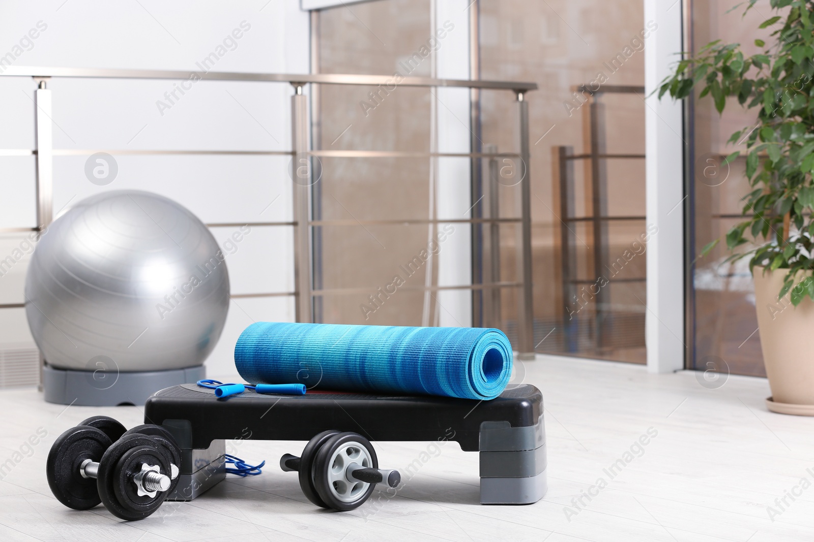 Photo of Set of fitness equipment of floor indoors. Space for text