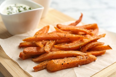 Sweet potato fries on wooden board, closeup