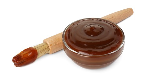 Photo of Tasty barbecue sauce in bowl and brush isolated on white