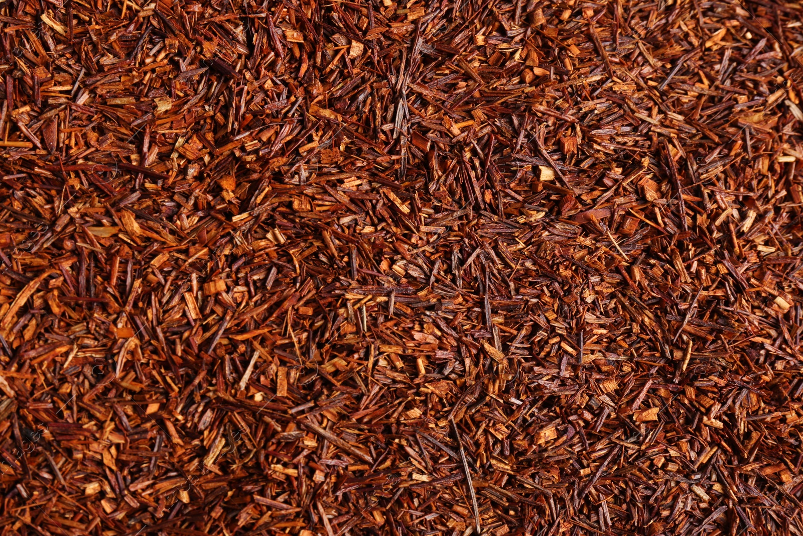 Photo of Heap of dry rooibos tea leaves as background, top view