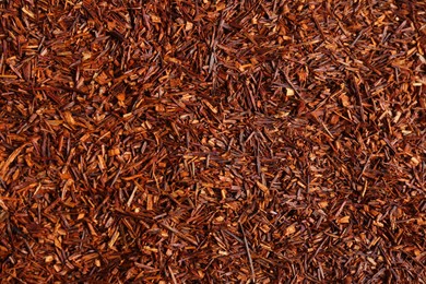 Heap of dry rooibos tea leaves as background, top view