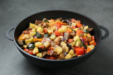 Photo of Delicious ratatouille in baking dish on grey table, closeup
