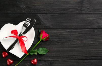 Photo of Beautiful table setting on black wooden background, flat lay with space for text. Valentine's Day dinner