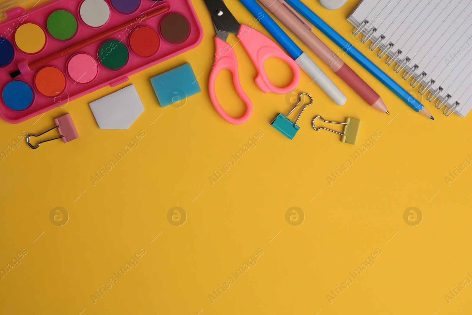 Photo of Flat lay composition with notebook and other school stationery on orange background, space for text. Back to school