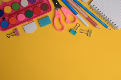 Photo of Flat lay composition with notebook and other school stationery on orange background, space for text. Back to school