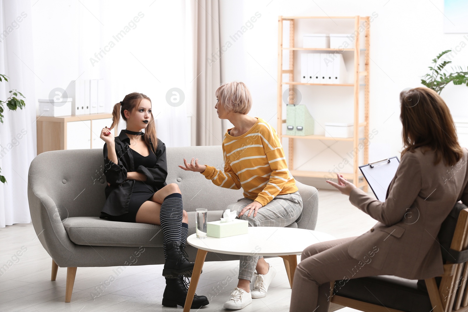 Photo of Psychotherapist working with teenage goth girl and her mother in office