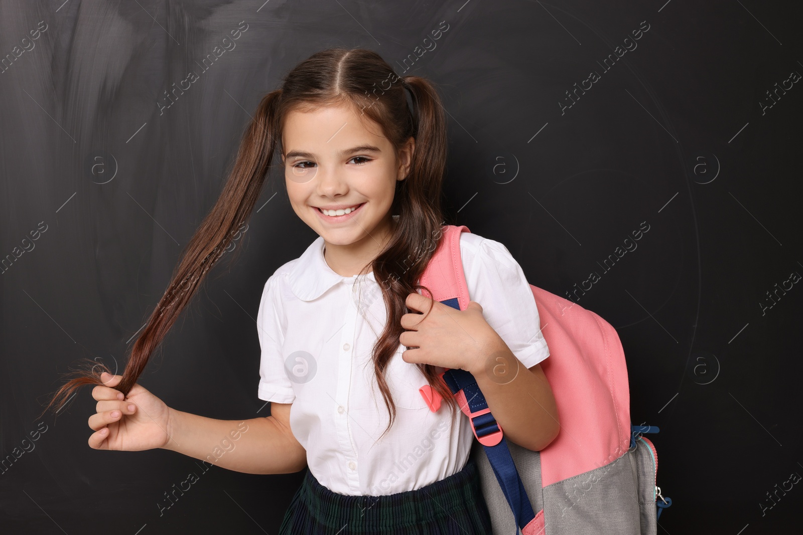 Photo of Back to school. Cute girl with backpack near chalkboard