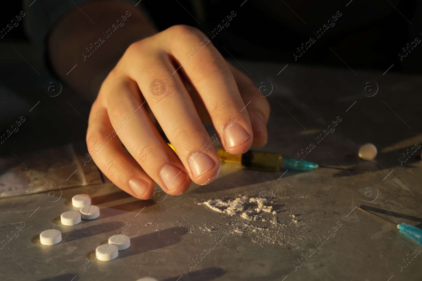 Photo of Addicted man with drugs at grey textured table, closeup