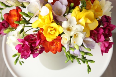 Photo of Bouquet of beautiful spring freesia flowers on table