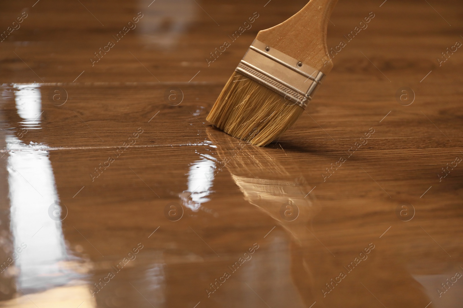 Photo of Varnishing wooden surface with brush, closeup view