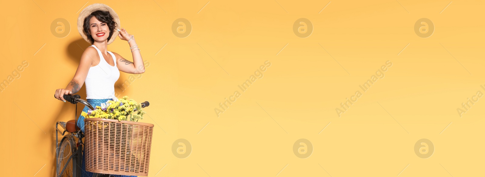 Image of Portrait of beautiful young woman with bicycle on yellow background, space for text. Banner design