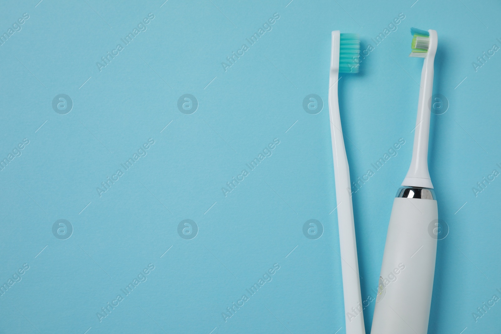 Photo of Electric and plastic toothbrushes on turquoise background, flat lay. Space for text