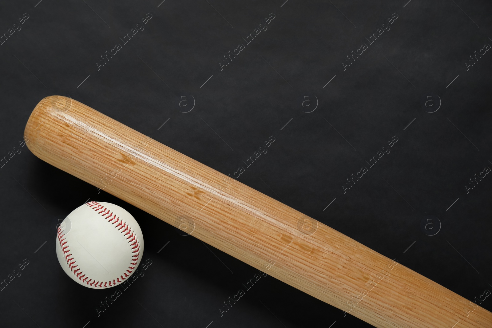 Photo of Wooden baseball bat and ball on black background, flat lay. Space for text