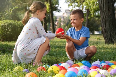 Photo of Little children with water bombs in park