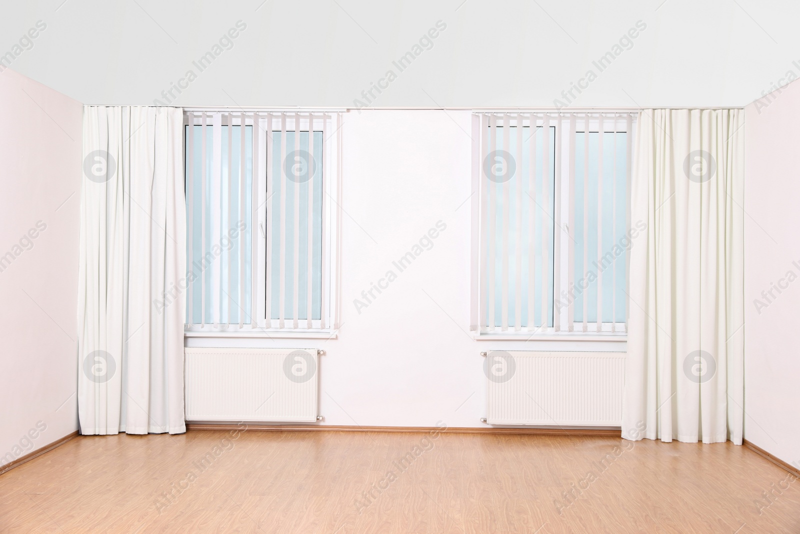 Photo of Windows with elegant curtains and blinds in empty room