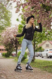 Photo of Young woman roller skating on spring day