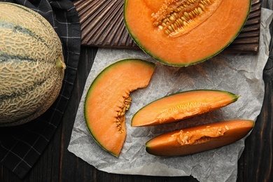 Flat lay composition with ripe cantaloupe melon on black wooden table