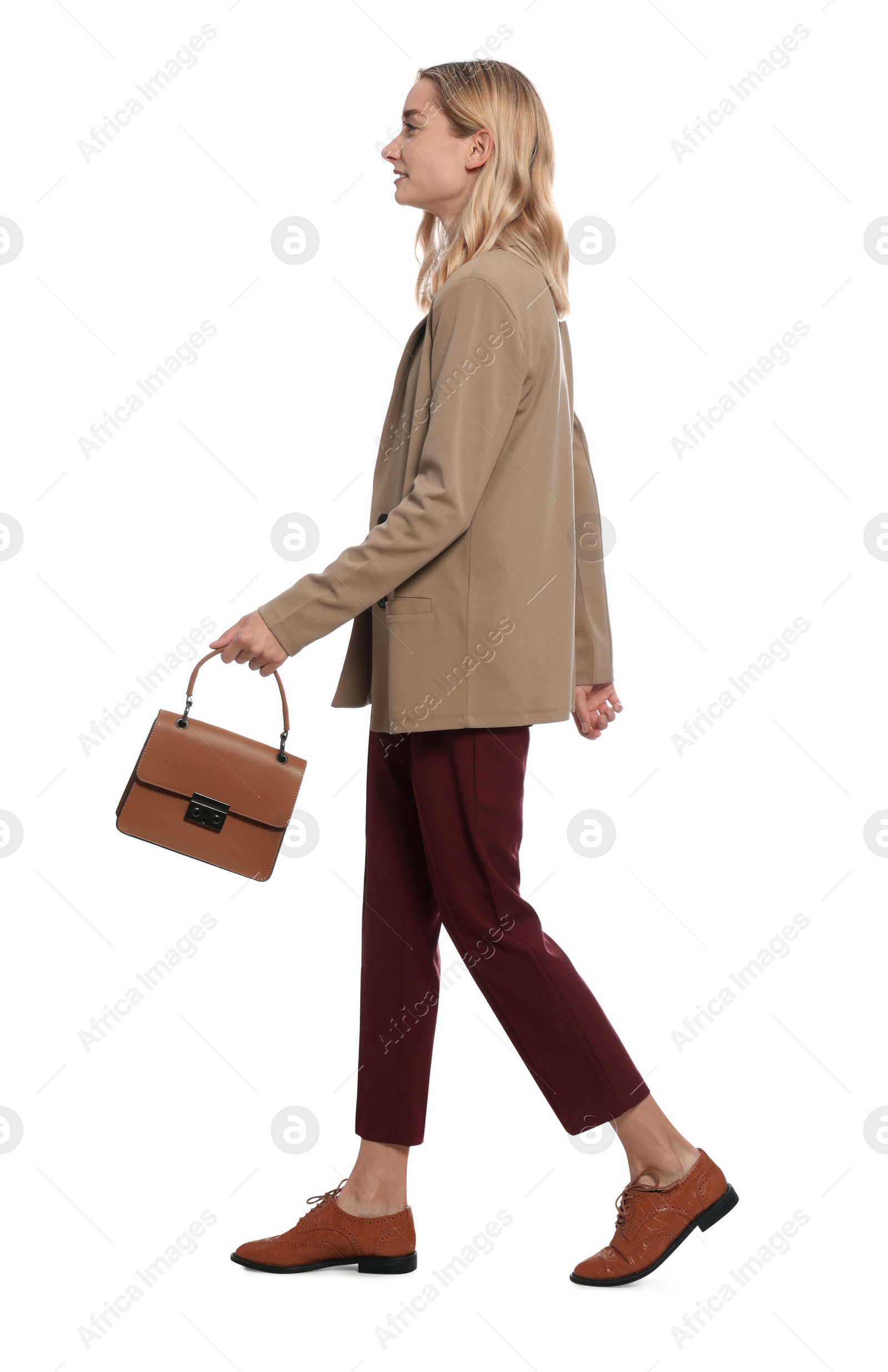 Photo of Young woman carrying bag and walking against white background