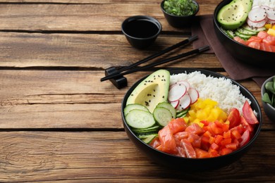 Delicious poke bowl with salmon and vegetables served on wooden table. Space for text