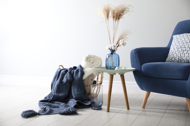 Photo of Basket with soft plaids in living room interior