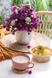 Photo of Cup of aromatic coffee and beautiful flowers on white table