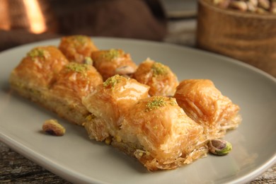 Photo of Delicious baklava with pistachio nuts on table, closeup