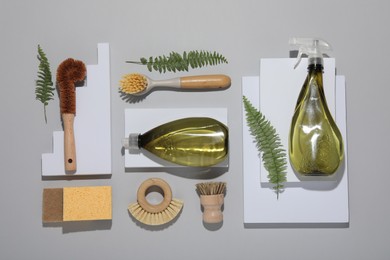 Photo of Flat lay composition with different cleaning supplies on light gray background