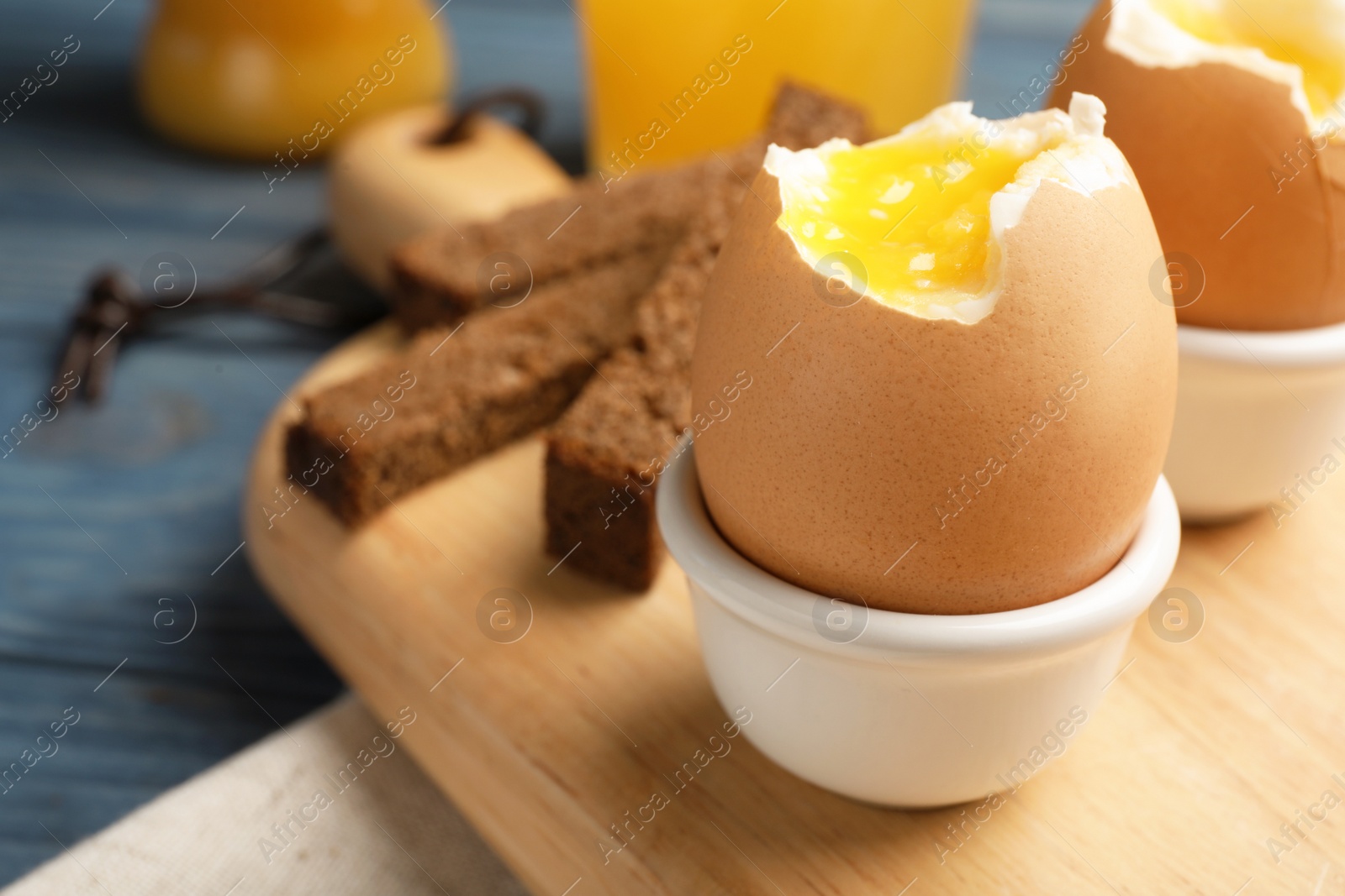 Photo of Holder with soft boiled egg on table. Space for text