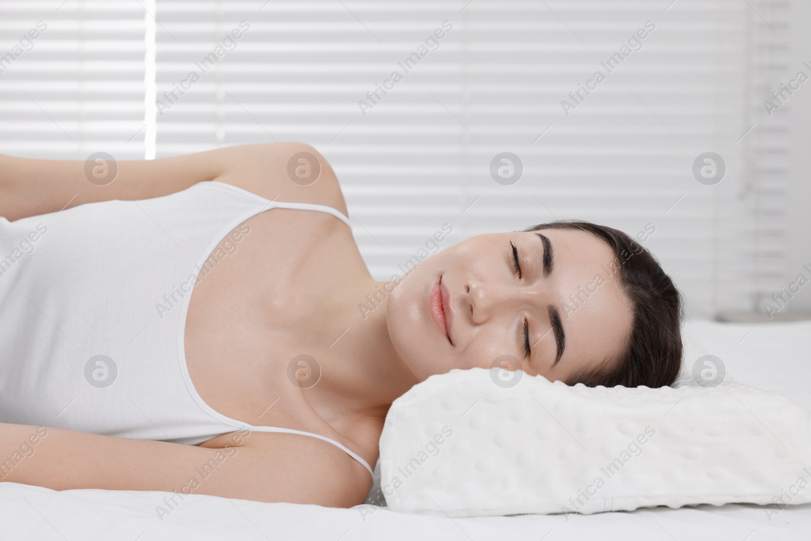 Photo of Woman sleeping on orthopedic pillow at home