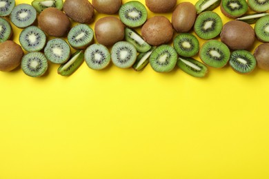 Many cut and whole fresh ripe kiwis on yellow background, flat lay. Space for text