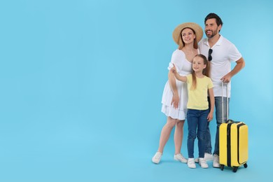 Happy family with yellow suitcase on light blue background, space for text