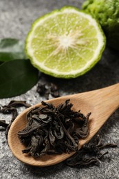 Photo of Dry bergamot tea leaves and fresh fruit on grey table, closeup