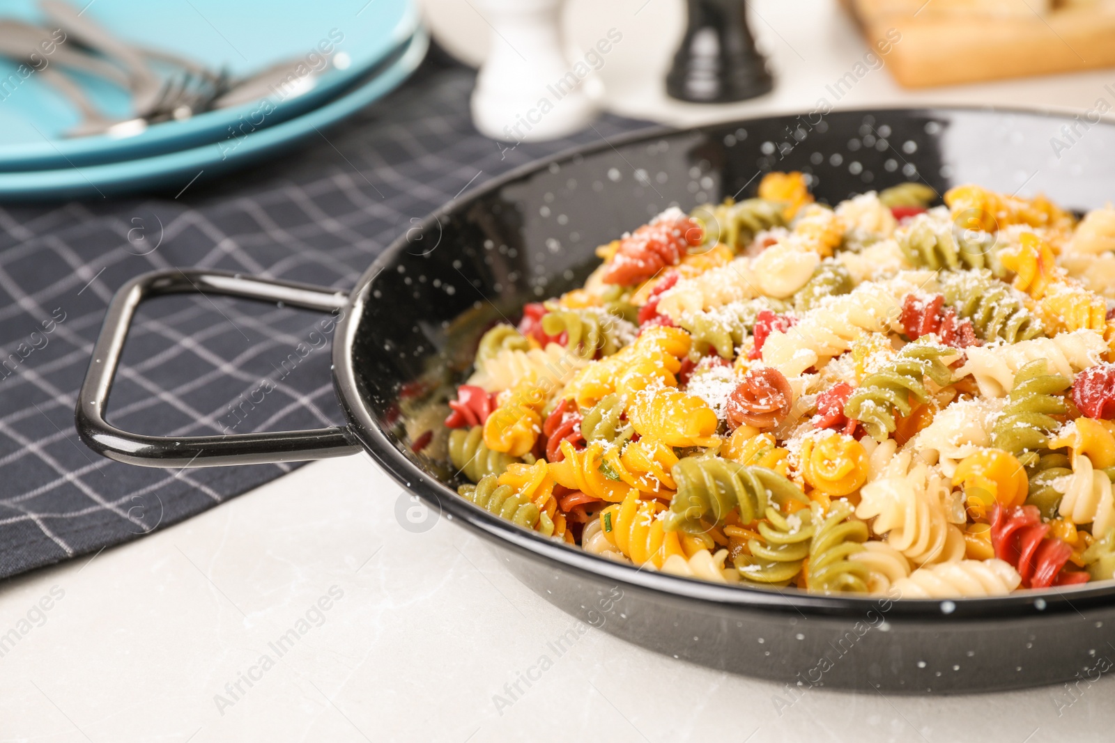 Photo of Colorful pasta with cheese on light grey marble table, closeup