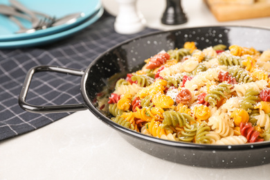 Photo of Colorful pasta with cheese on light grey marble table, closeup