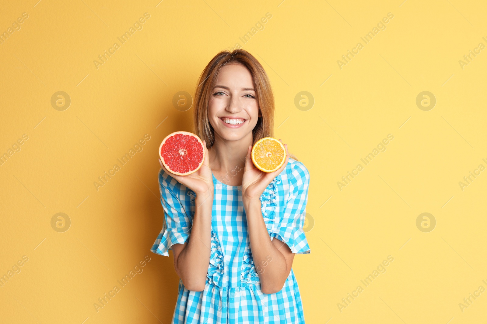 Photo of Happy slim woman with grapefruit and orange on color background. Weight loss diet