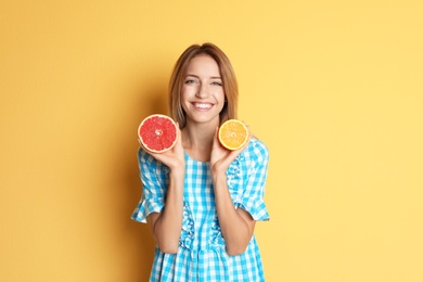 Happy slim woman with grapefruit and orange on color background. Weight loss diet