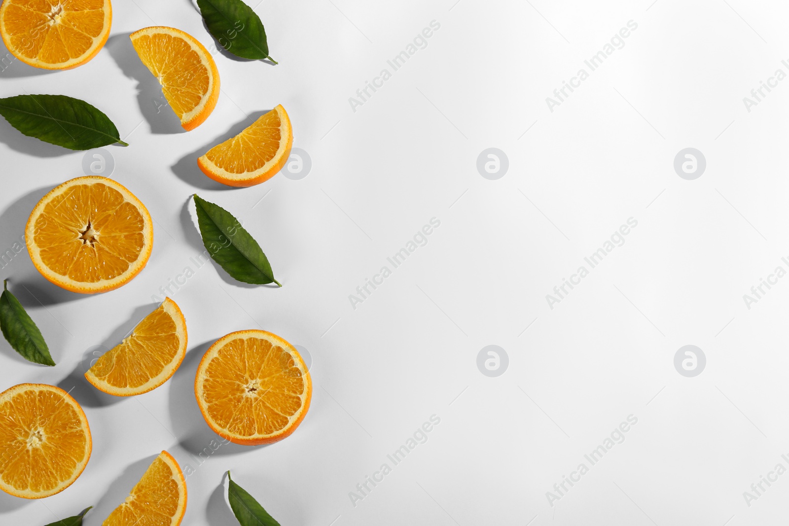 Photo of Slices of delicious oranges on white background, flat lay. Space for text