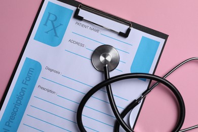 Photo of Clipboard with medical prescription form and stethoscope on pink background, flat lay