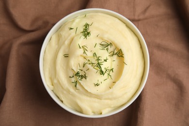 Photo of Freshly cooked homemade mashed potatoes on brown fabric, top view