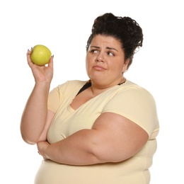 Emotional overweight woman with apple on white background