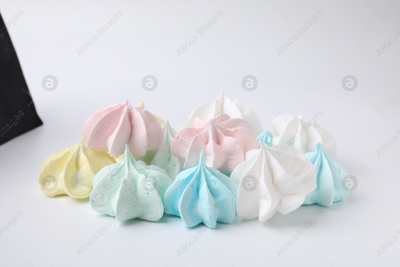 Photo of Many delicious meringue cookies isolated on white