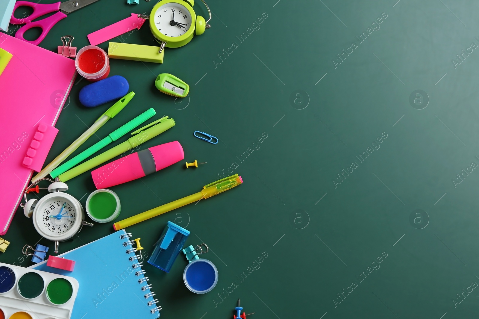 Photo of Different bright school stationery on green background, flat lay. Space for text