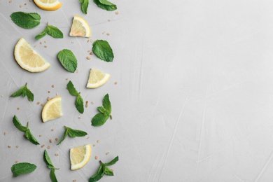 Fresh mint with sliced lemon and sugar on grey background, flat lay. Space for text