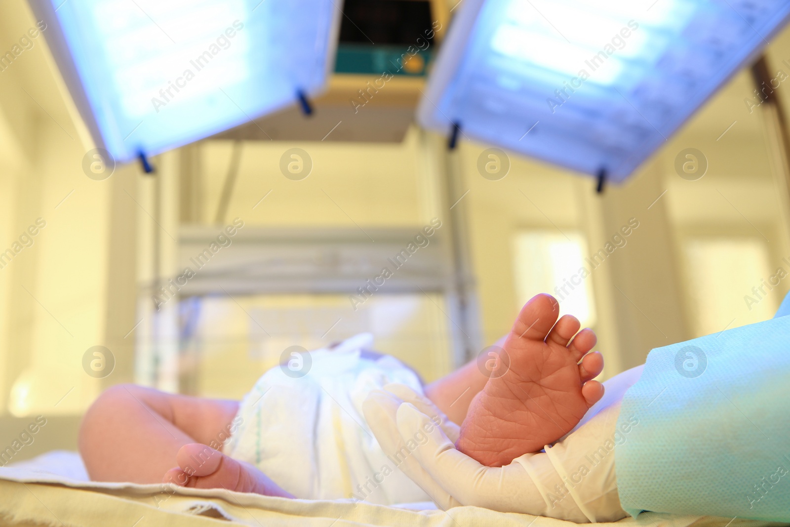 Photo of Doctor holding newborn child's foot in hospital, closeup