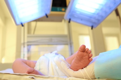 Photo of Doctor holding newborn child's foot in hospital, closeup